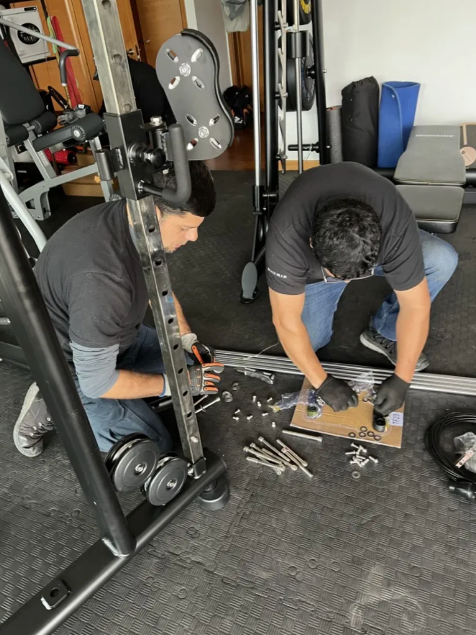 Equipo de M4 Fitness instalando máquinas en una sala institucional